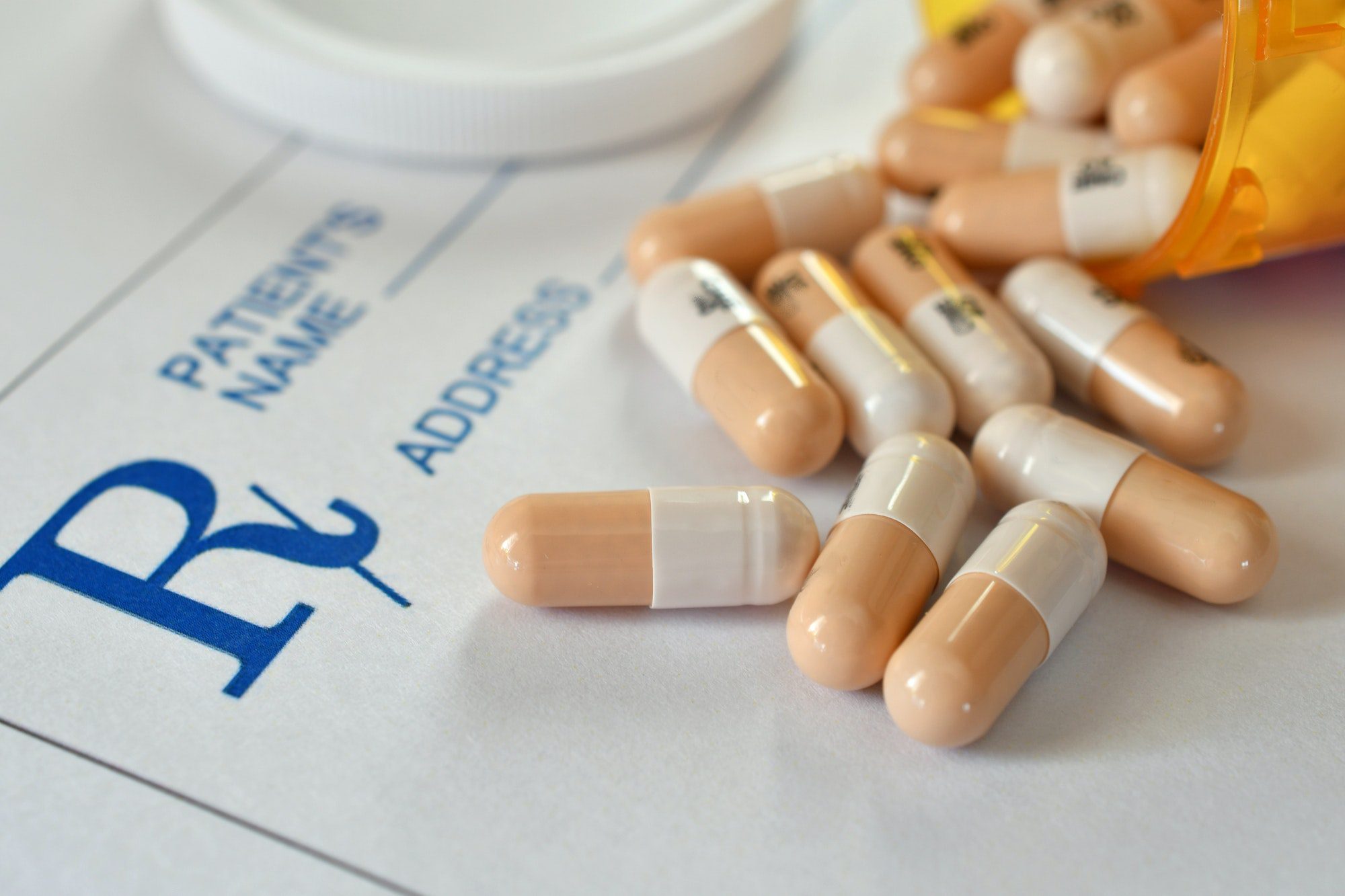 Pills, medicine, and pharmaceutical drugs laying on a Prescription Drug Coverage RX pad.
