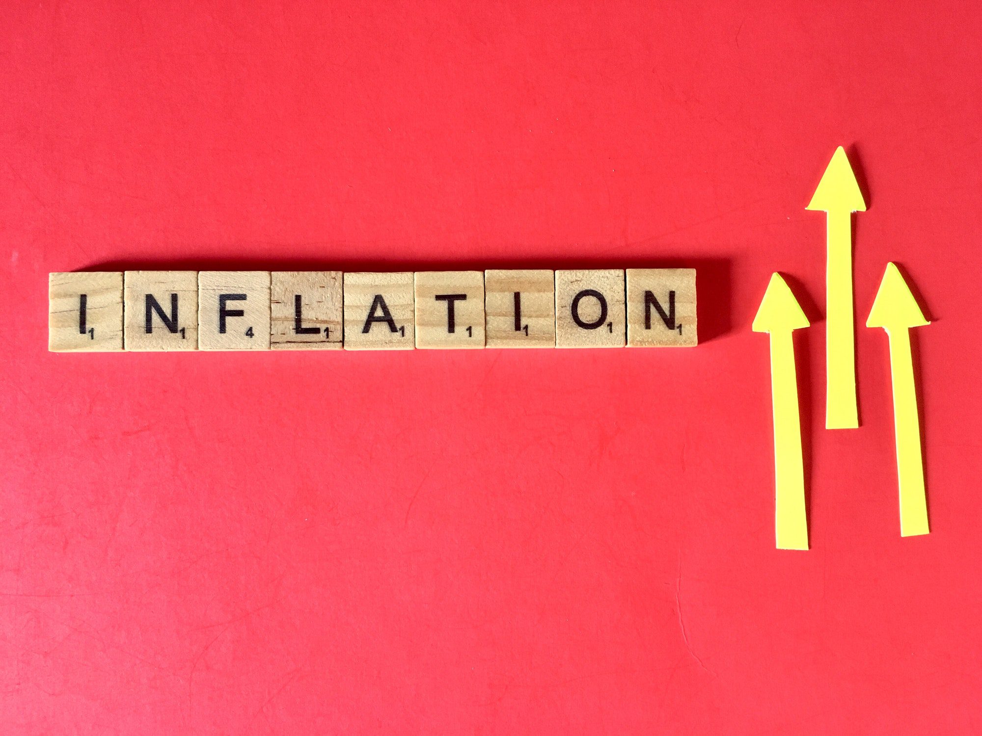 Inflation spelled out with wooden blocks on red background, referring to the Medicare Premium increases.