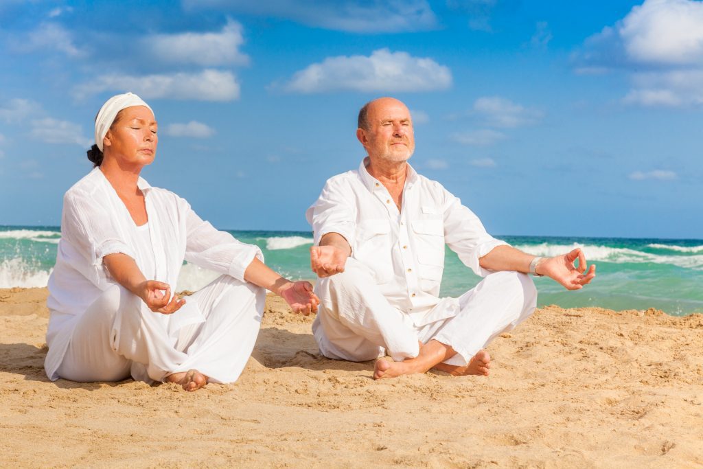 Couple relaxing on the beach as they discuss their supplement plan N.