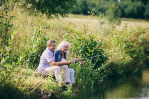 Senior couple fishing and discussing Medicare Advantage Penetration Rates.