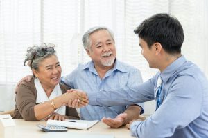 Happy senior couple handshaking with Medicare agent
